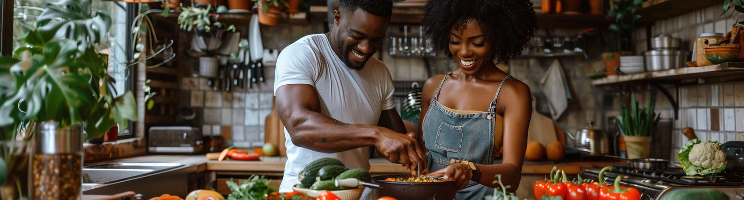 A couple with beaming smiles preparing a fresh, wholesome meal with A.Vogel Multiforce alkaline powder, surrounded by a variety of vibrant vegetables in a home kitchen, epitomising health and happiness, available at The Good Stuff Health Shop.