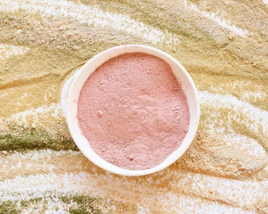Collagen supplements powder in a white bowl on a multicoloured superfood background – The Good Stuff health and beauty range