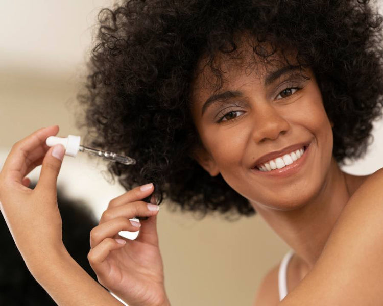 Smiling woman applying hair serum with dropper, representing Glutathione South Africa supplement benefits – The Good Stuff South Africa