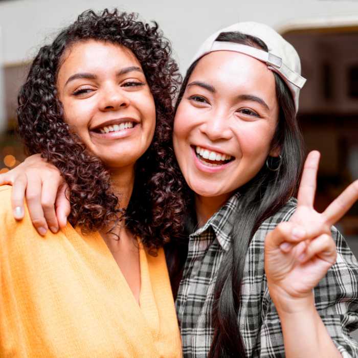 Two friends smiling and embracing, symbolising the energy and vitality supported by iron supplements – The Good Stuff.