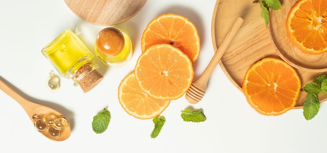 Sliced oranges on a white background with wooden spoons and a wooden board.